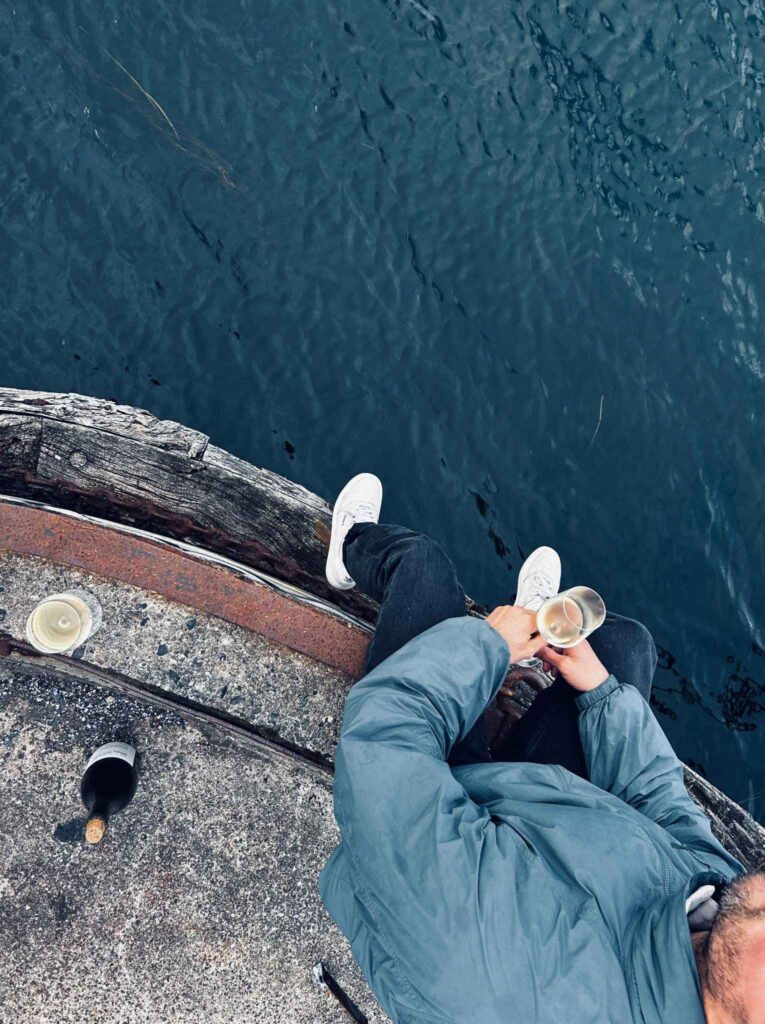 man sitting by Copenhagen harbour drinking a glass of white wine